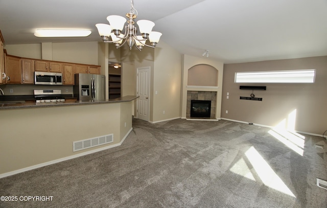 11613 Birch Knoll Loop, Anchorage, AK 99515 - kitchen featuring stainless steel appliances, lofted ceiling, dark countertops, a chandelier, and brown cabinets