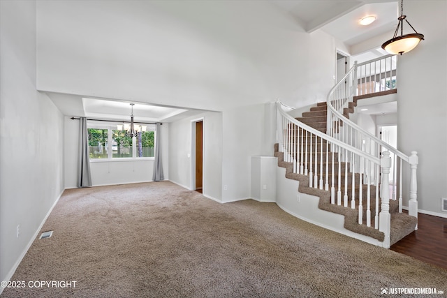 3561 Eastwind Dr, Anchorage, AK 99516 - unfurnished living room featuring a chandelier, stairs, and carpet flooring