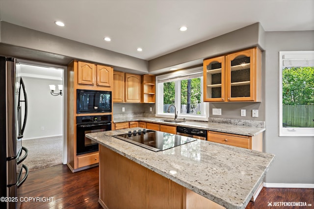 3561 Eastwind Dr, Anchorage, AK 99516 - kitchen with black appliances, a center island, light stone countertops, dark wood-style floors, and glass insert cabinets