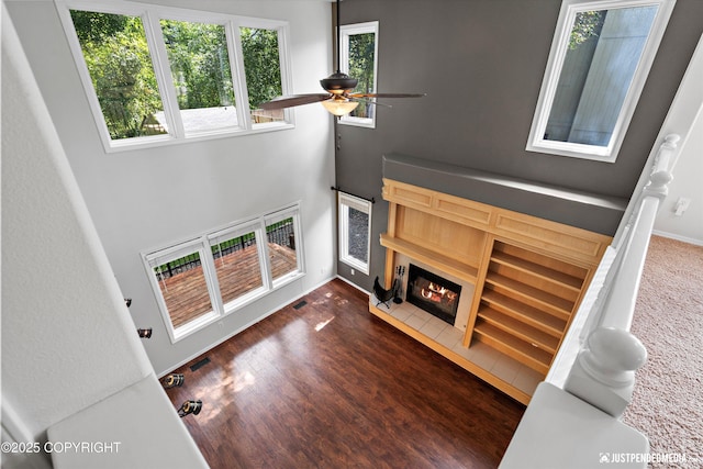 3561 Eastwind Dr, Anchorage, AK 99516 - living area with a glass covered fireplace, a ceiling fan, wood finished floors, and a high ceiling