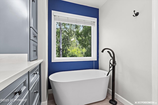 3561 Eastwind Dr, Anchorage, AK 99516 - bathroom featuring a freestanding bath, vanity, and wood finished floors