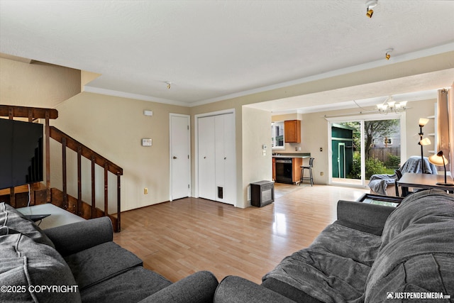 8051 Evans Cir, Anchorage, AK 99507 - living area with a chandelier, light wood finished floors, stairway, and crown molding
