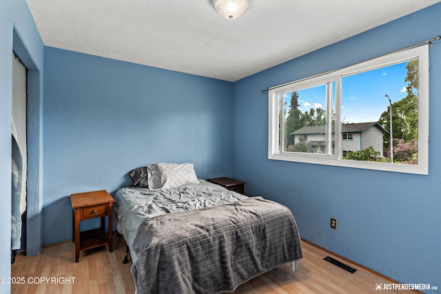 8051 Evans Cir, Anchorage, AK 99507 - bedroom with wood finished floors and a textured wall