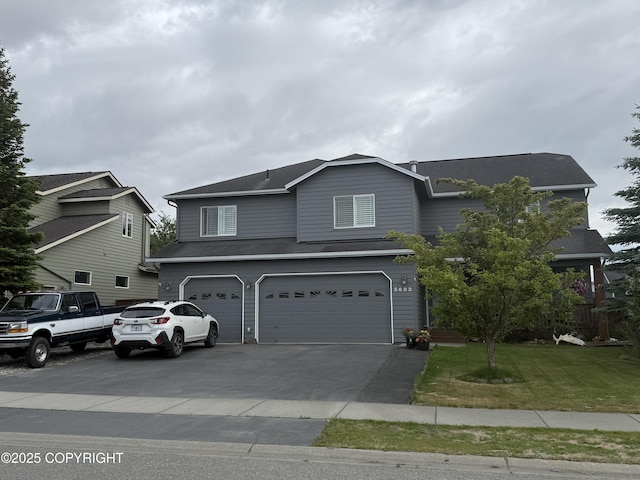 5693 Yukon Charlie Loop, Anchorage, AK 99502 - traditional-style house with an attached garage, driveway, and a front yard