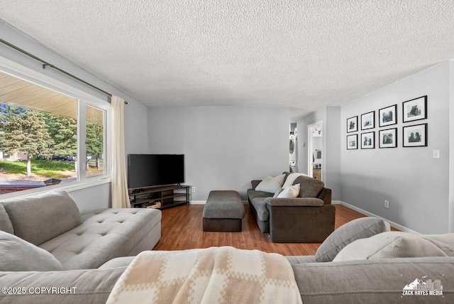 7200 Kiska Cir, Anchorage, AK 99504 - living room featuring stacked washer and clothes dryer, wood finished floors, and a textured ceiling