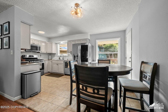 7200 Kiska Cir, Anchorage, AK 99504 - dining space with healthy amount of natural light, a textured ceiling, and light tile patterned flooring