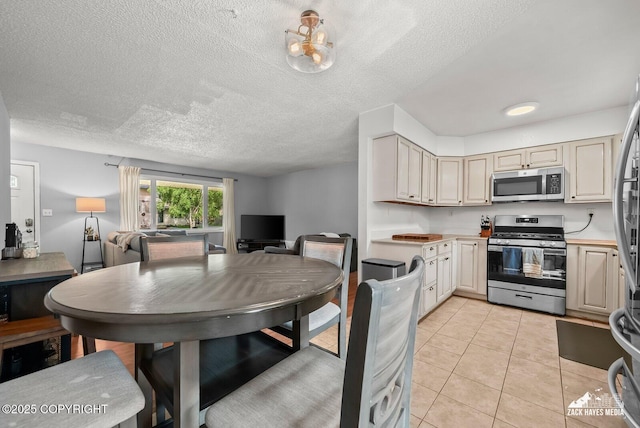 7200 Kiska Cir, Anchorage, AK 99504 - kitchen featuring appliances with stainless steel finishes, open floor plan, light countertops, light tile patterned floors, and a textured ceiling