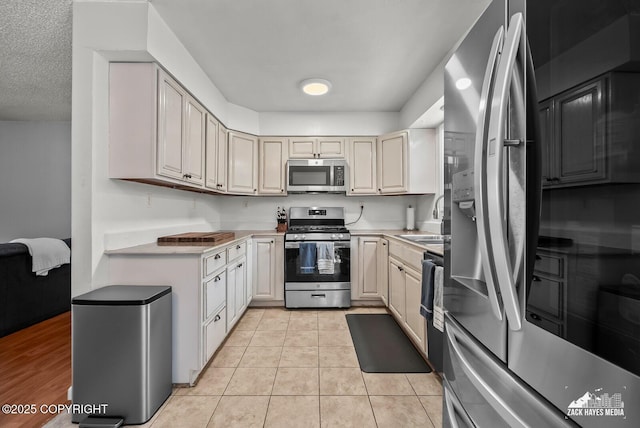 7200 Kiska Cir, Anchorage, AK 99504 - kitchen featuring appliances with stainless steel finishes, light countertops, and light tile patterned flooring