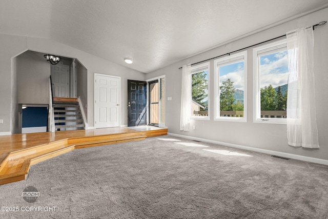 9645 Nulato Cir, Eagle River, AK 99577 - unfurnished living room featuring vaulted ceiling, carpet flooring, a chandelier, and stairs