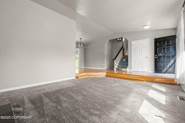9645 Nulato Cir, Eagle River, AK 99577 - unfurnished living room featuring carpet floors, stairway, and lofted ceiling