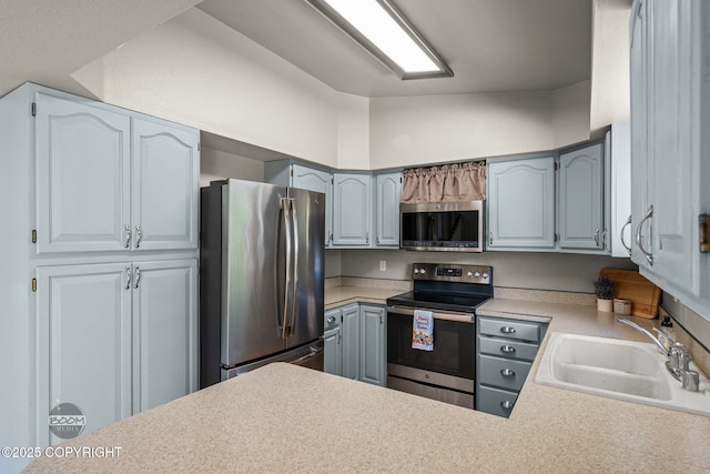 9645 Nulato Cir, Eagle River, AK 99577 - kitchen featuring stainless steel appliances, light countertops, a peninsula, and gray cabinetry