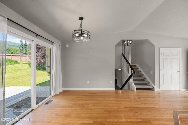 9645 Nulato Cir, Eagle River, AK 99577 - unfurnished dining area featuring a chandelier, light wood finished floors, stairs, and vaulted ceiling