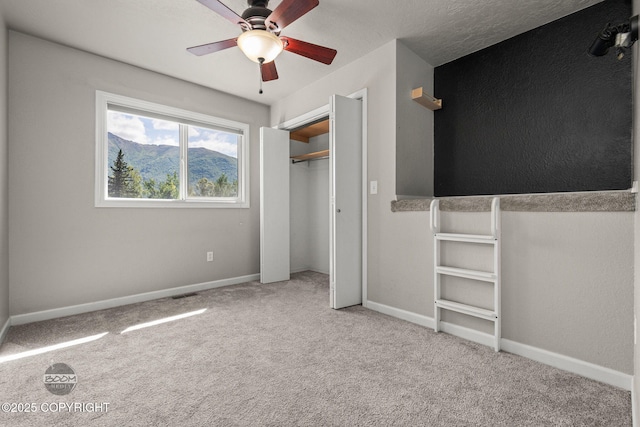 9645 Nulato Cir, Eagle River, AK 99577 - unfurnished bedroom with carpet flooring, a mountain view, and a ceiling fan