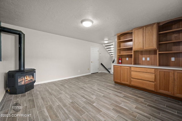 9645 Nulato Cir, Eagle River, AK 99577 - unfurnished living room with wood finished floors, a textured ceiling, and a wood stove