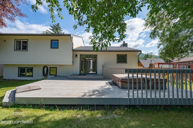 9645 Nulato Cir, Eagle River, AK 99577 - back of house with a hot tub, a wooden deck, and a chimney