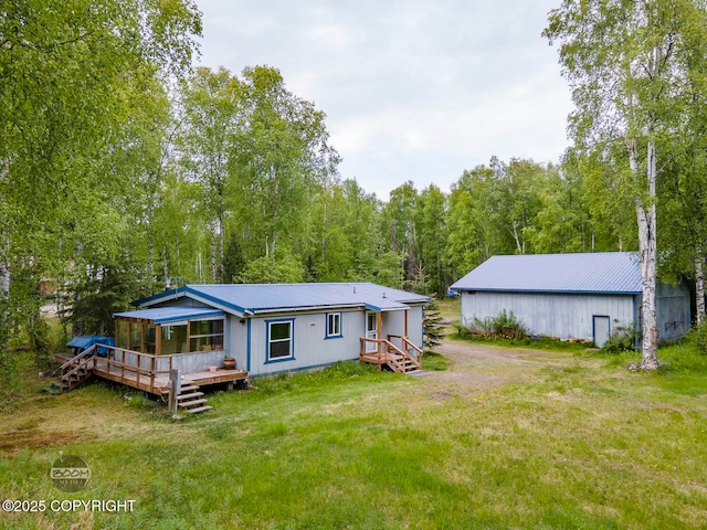 1801 W That Rd, Wasilla, AK 99623 - rear view of property featuring a metal roof, a yard, a deck, and a view of trees