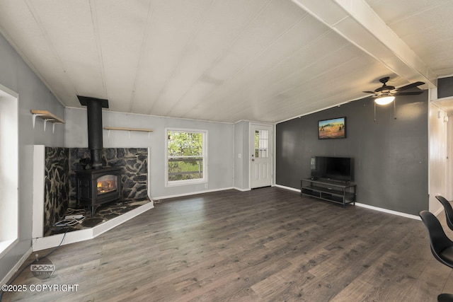 1801 W That Rd, Wasilla, AK 99623 - unfurnished living room featuring a wood stove, wood finished floors, and ceiling fan