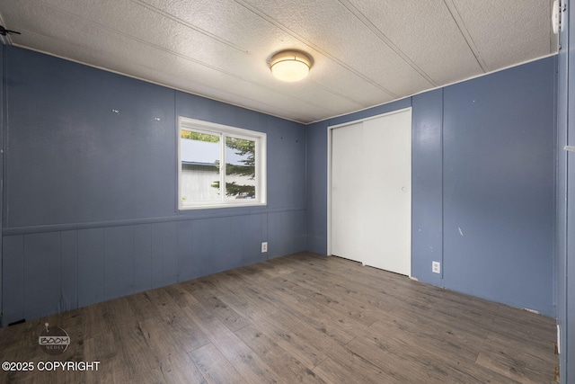 1801 W That Rd, Wasilla, AK 99623 - unfurnished bedroom with wood finished floors, a textured ceiling, and a closet