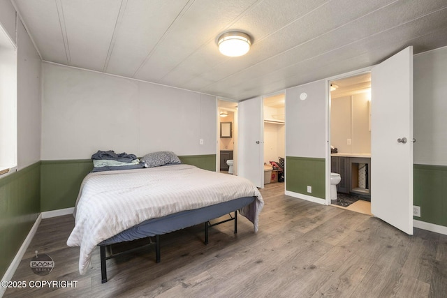 1801 W That Rd, Wasilla, AK 99623 - bedroom with wood finished floors, a wainscoted wall, a spacious closet, and ensuite bath