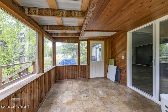 1801 W That Rd, Wasilla, AK 99623 - unfurnished sunroom featuring wooden walls, stone finish flooring, and plenty of natural light
