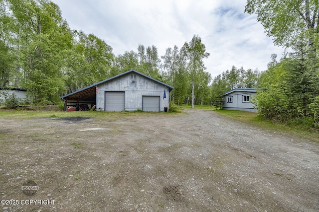 1801 W That Rd, Wasilla, AK 99623 - garage featuring a garage and view of scattered trees