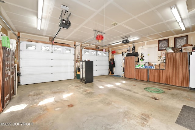 48350 Lakeside Ave, Soldotna, AK 99669 - garage featuring a garage door opener and refrigerator