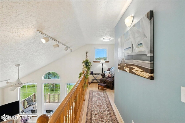 48350 Lakeside Ave, Soldotna, AK 99669 - hallway with a textured ceiling, lofted ceiling, track lighting, and wood finished floors
