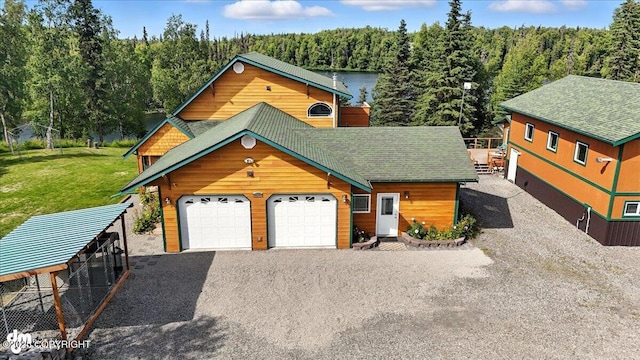 48350 Lakeside Ave, Soldotna, AK 99669 - rustic home with a forest view, gravel driveway, a shingled roof, a front yard, and an outdoor structure