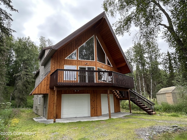 172 Linda Ln, Soldotna, AK 99669 - back of property featuring stairs, an attached garage, a wooden deck, a shed, and a yard