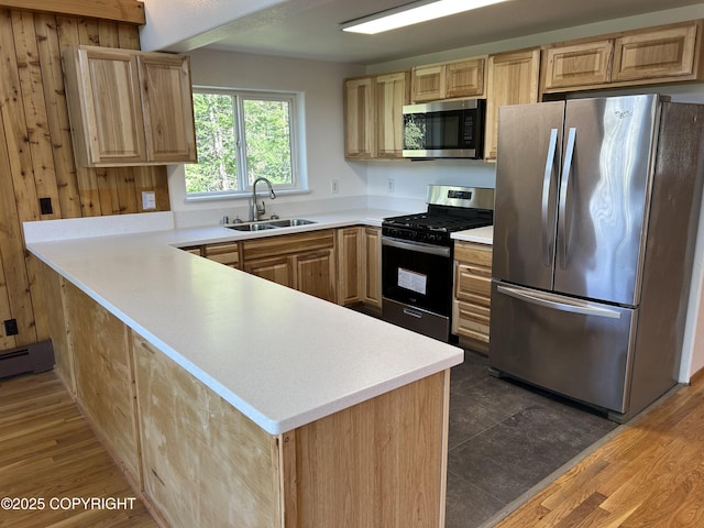 172 Linda Ln, Soldotna, AK 99669 - kitchen featuring appliances with stainless steel finishes, light brown cabinetry, a peninsula, and light countertops