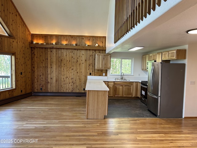 172 Linda Ln, Soldotna, AK 99669 - kitchen with stainless steel appliances, wood finished floors, light countertops, a peninsula, and wood walls