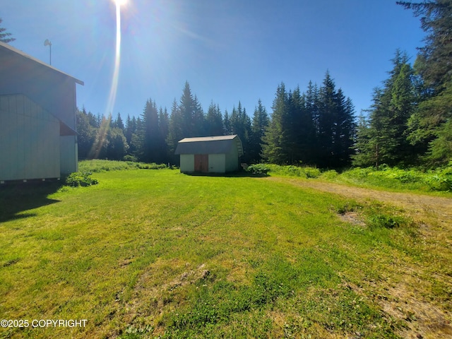 35196 Nordic Ct, Anchor Point, AK 99556 - view of grassy yard with a storage unit and a view of trees