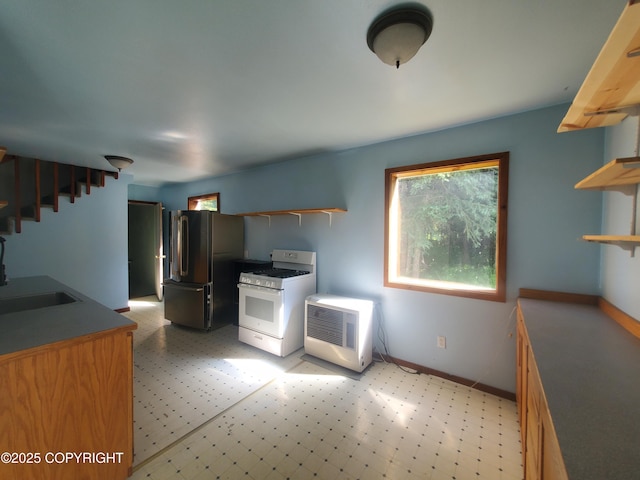 35196 Nordic Ct, Anchor Point, AK 99556 - kitchen with open shelves, freestanding refrigerator, white gas range, light floors, and heating unit