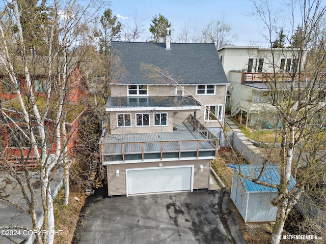 1334 K St, Anchorage, AK 99501 - rear view of house with driveway, a garage, a shingled roof, and a balcony