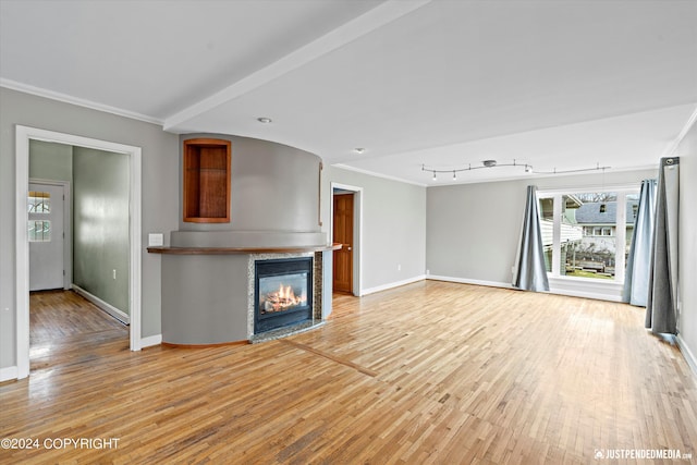 1334 K St, Anchorage, AK 99501 - unfurnished living room featuring ornamental molding, a glass covered fireplace, and light wood-style flooring