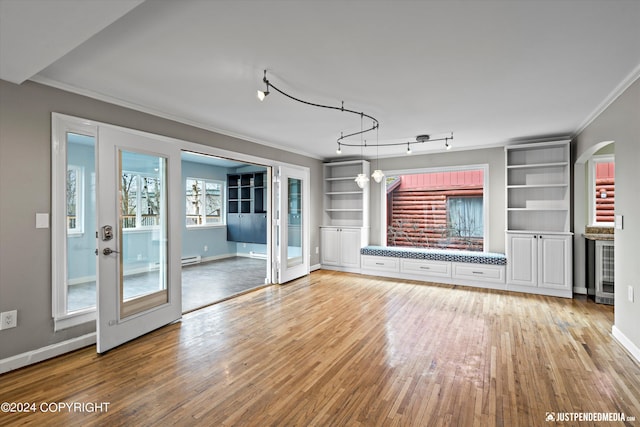 1334 K St, Anchorage, AK 99501 - unfurnished living room with ornamental molding, light wood-style flooring, built in shelves, beverage cooler, and arched walkways