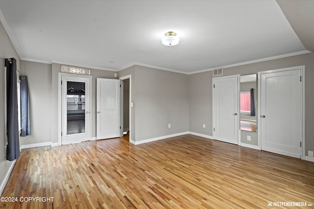 1334 K St, Anchorage, AK 99501 - unfurnished bedroom featuring light wood finished floors, two closets, and ornamental molding