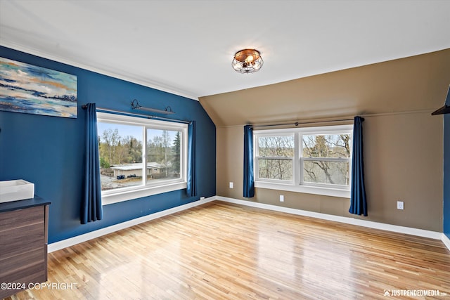 1334 K St, Anchorage, AK 99501 - empty room featuring vaulted ceiling, healthy amount of natural light, and wood finished floors