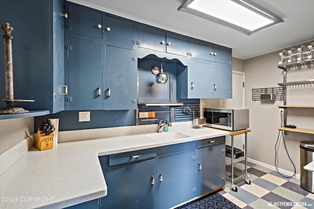 1334 K St, Anchorage, AK 99501 - kitchen featuring stainless steel microwave, blue cabinetry, light flooring, and light countertops