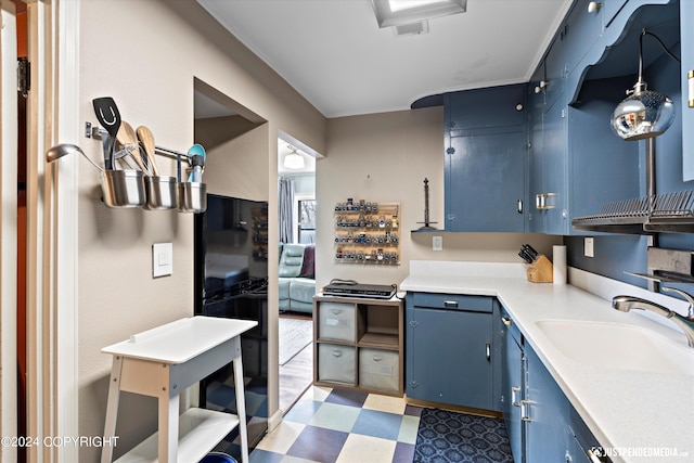 1334 K St, Anchorage, AK 99501 - kitchen with blue cabinetry, tile patterned floors, light countertops, and crown molding