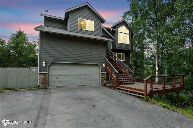 21009 River Park Dr, Eagle River, AK 99577 - view of front of property featuring an attached garage, asphalt driveway, stone siding, a deck, and stairway