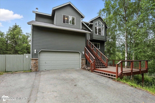 21009 River Park Dr, Eagle River, AK 99577 - view of front of house featuring a garage, asphalt driveway, stone siding, and a deck