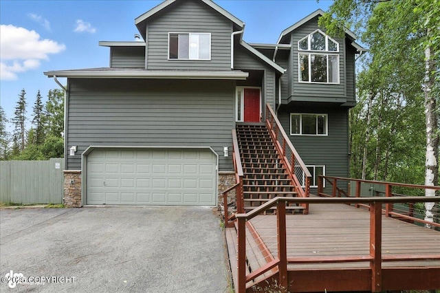 21009 River Park Dr, Eagle River, AK 99577 - view of front of house with an attached garage, asphalt driveway, stairs, a deck, and stone siding