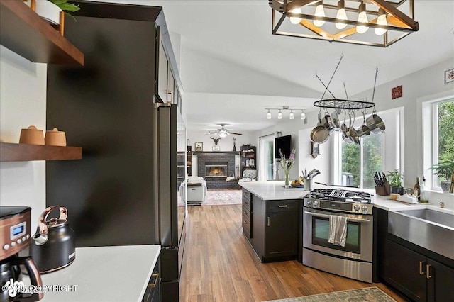 21009 River Park Dr, Eagle River, AK 99577 - kitchen featuring stainless steel range with gas cooktop, open floor plan, a chandelier, and light countertops