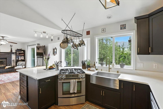 21009 River Park Dr, Eagle River, AK 99577 - kitchen with stainless steel gas range oven, a peninsula, light countertops, a ceiling fan, and open floor plan
