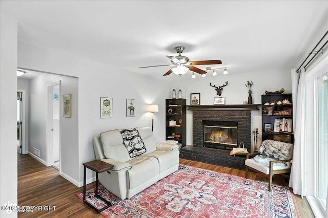 21009 River Park Dr, Eagle River, AK 99577 - living area featuring ceiling fan, wood finished floors, and a brick fireplace