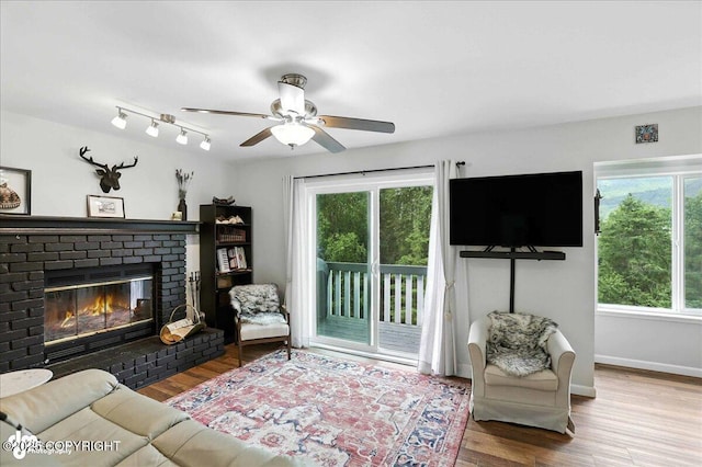 21009 River Park Dr, Eagle River, AK 99577 - living area with a fireplace, wood finished floors, and a ceiling fan