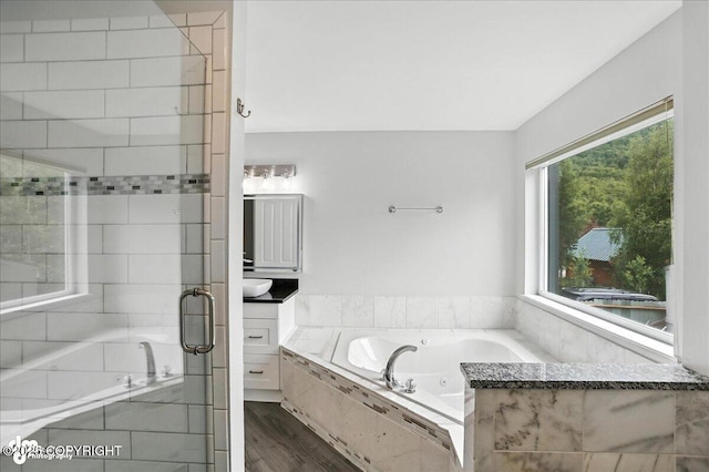 21009 River Park Dr, Eagle River, AK 99577 - full bath with vanity, a tub with jets, wood finished floors, and a stall shower