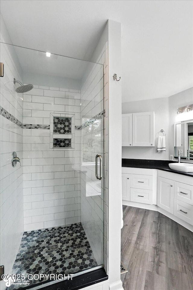 21009 River Park Dr, Eagle River, AK 99577 - full bathroom featuring vanity, a stall shower, and wood finished floors