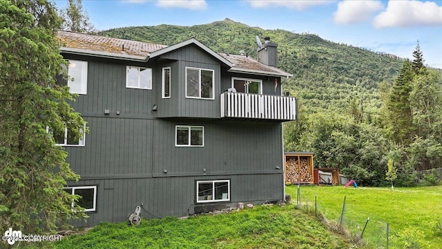 21009 River Park Dr, Eagle River, AK 99577 - rear view of house featuring a balcony, a chimney, and a mountain view